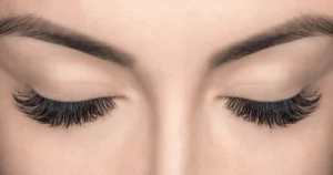 Close-up of closed eyes with thick lashes and defined brows after LATISSE eyelash treatment in Gilbert, AZ.